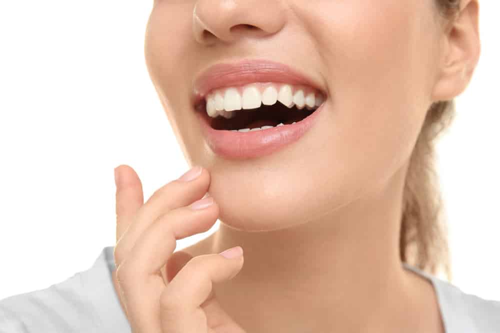 Young beautiful woman smiling on white background. Oral hygiene