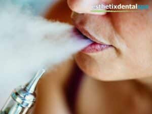 Close-up of a person vaping, highlighting the risks of Tooth Damage and oral health issues